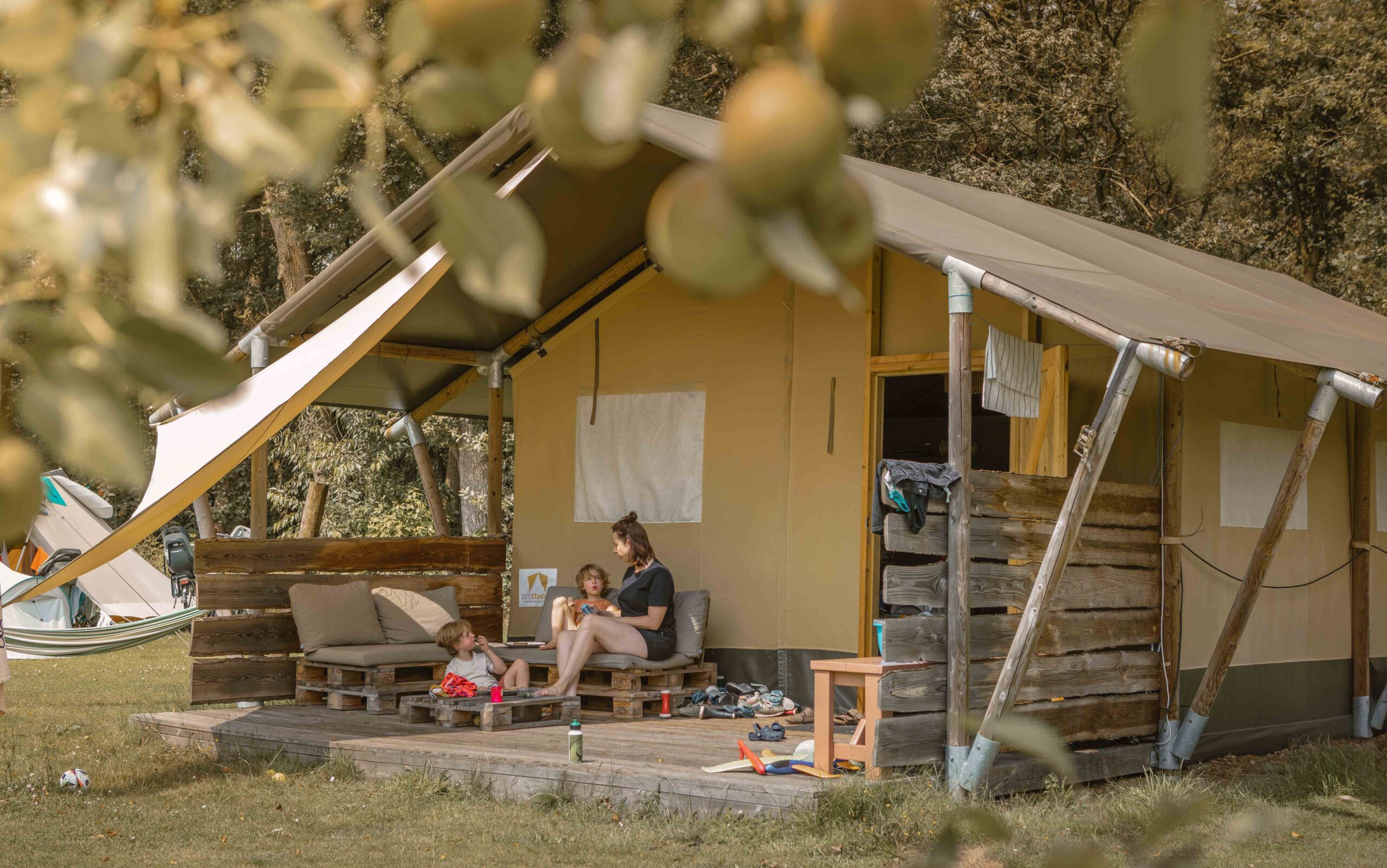 Gezin op het terras van de Lodgetent bij Lemeler Esch natuurcamping