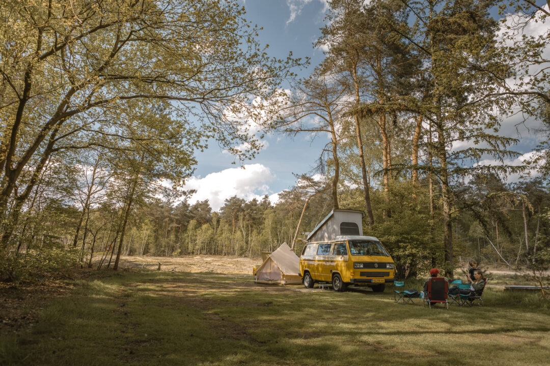 Gezin met camperbus op de bosplaats bij Lemeler Esch natuurcamping in Overijssel