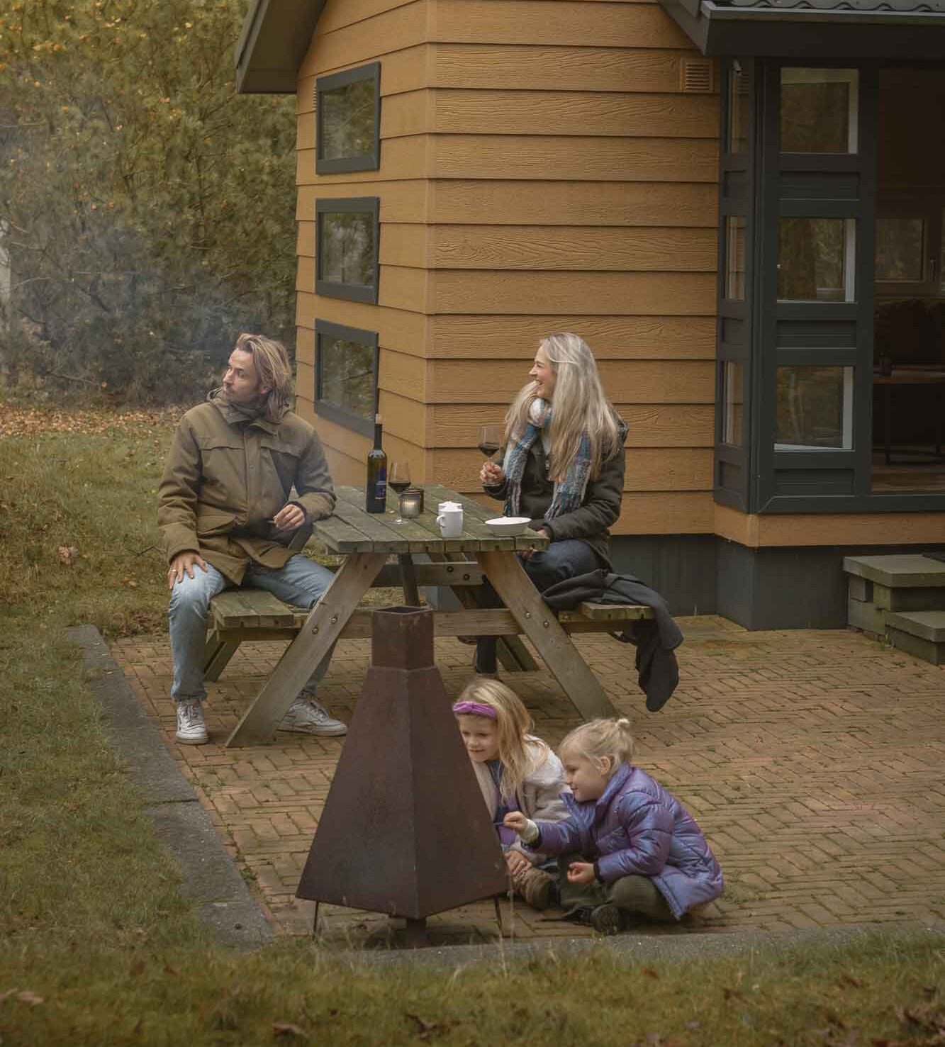 Gezin buiten bij de bungalow in de natuur bij Lemeler Esch natuurcamping in Overijssel
