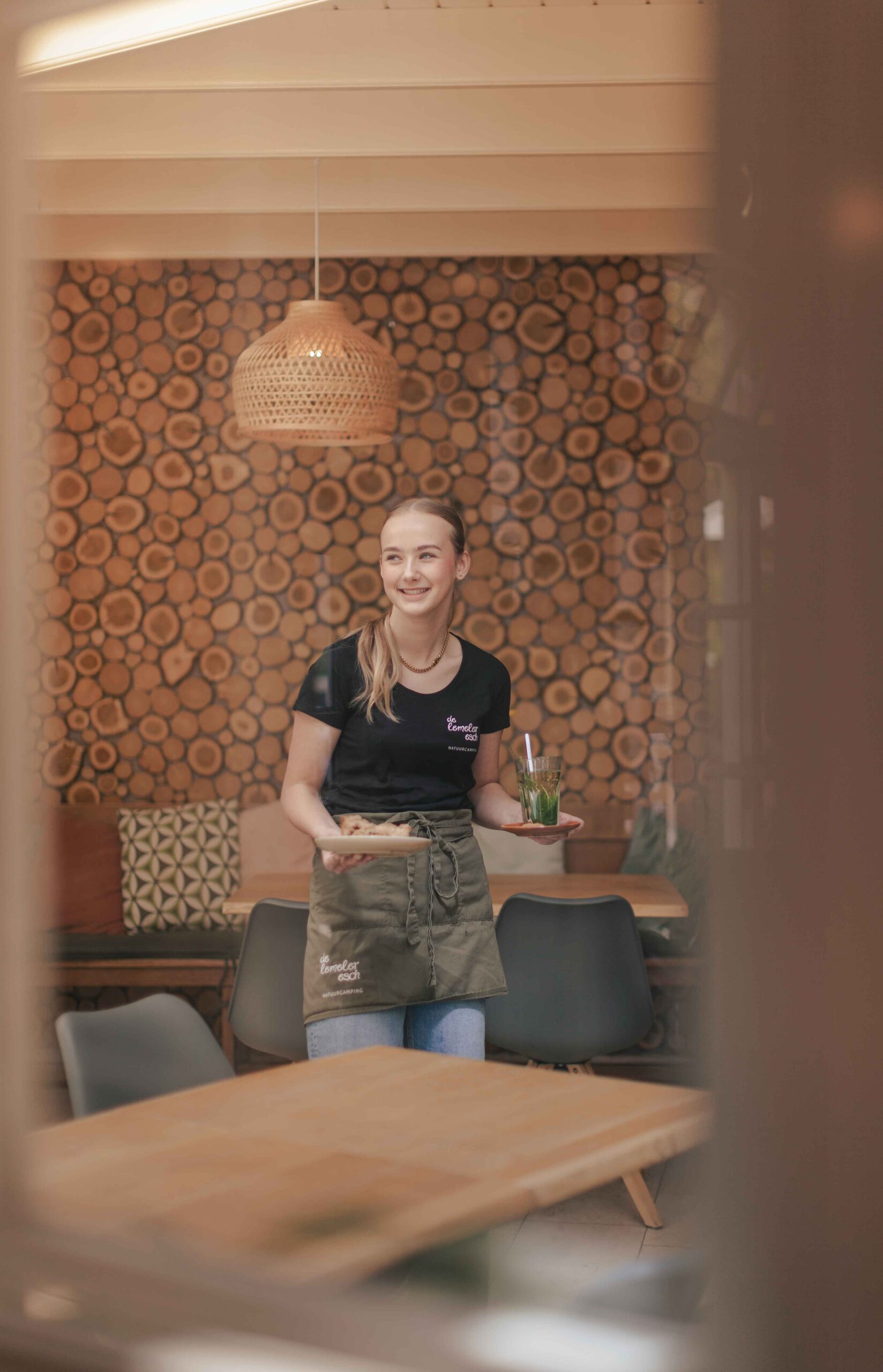 Collega in de serre van Boscafé Lemeler Esch met huisgemaakte taart en verse muntthee in haar hand