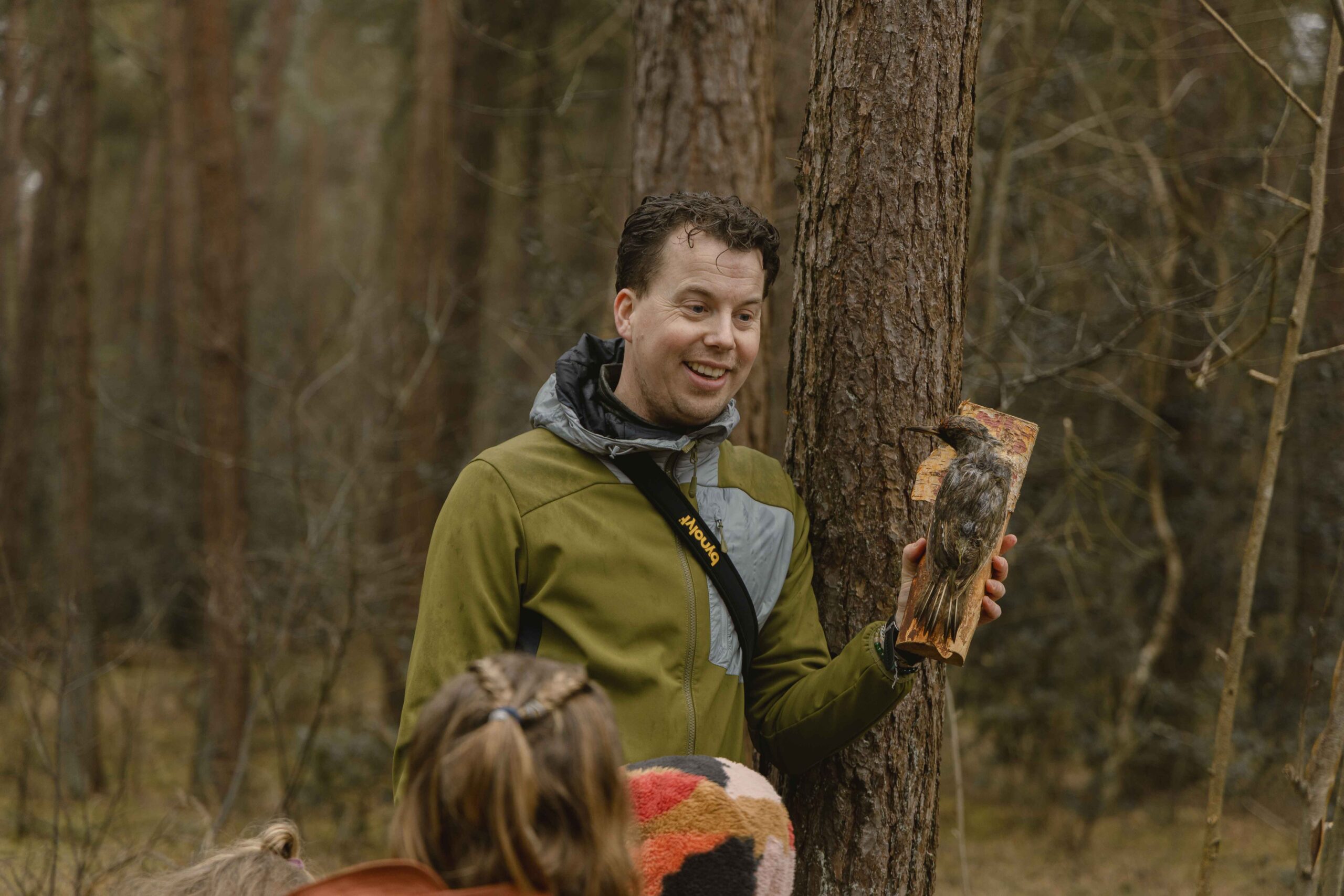 Bioloog Marijn met opgezette vogel in het bos tijdens bosexcursie bij Lemeler Esch