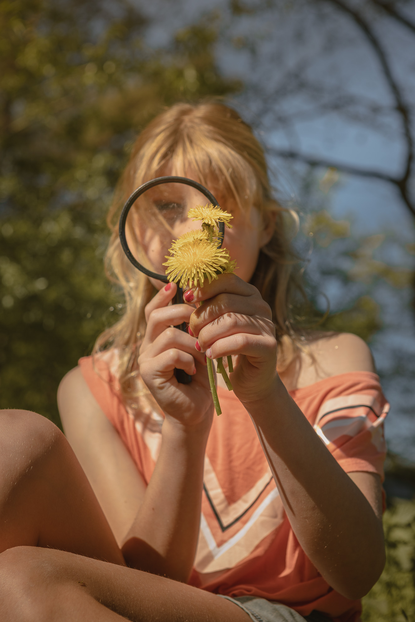 Meisje met vergrootglas en paardenbloem bij Lemeler Esch