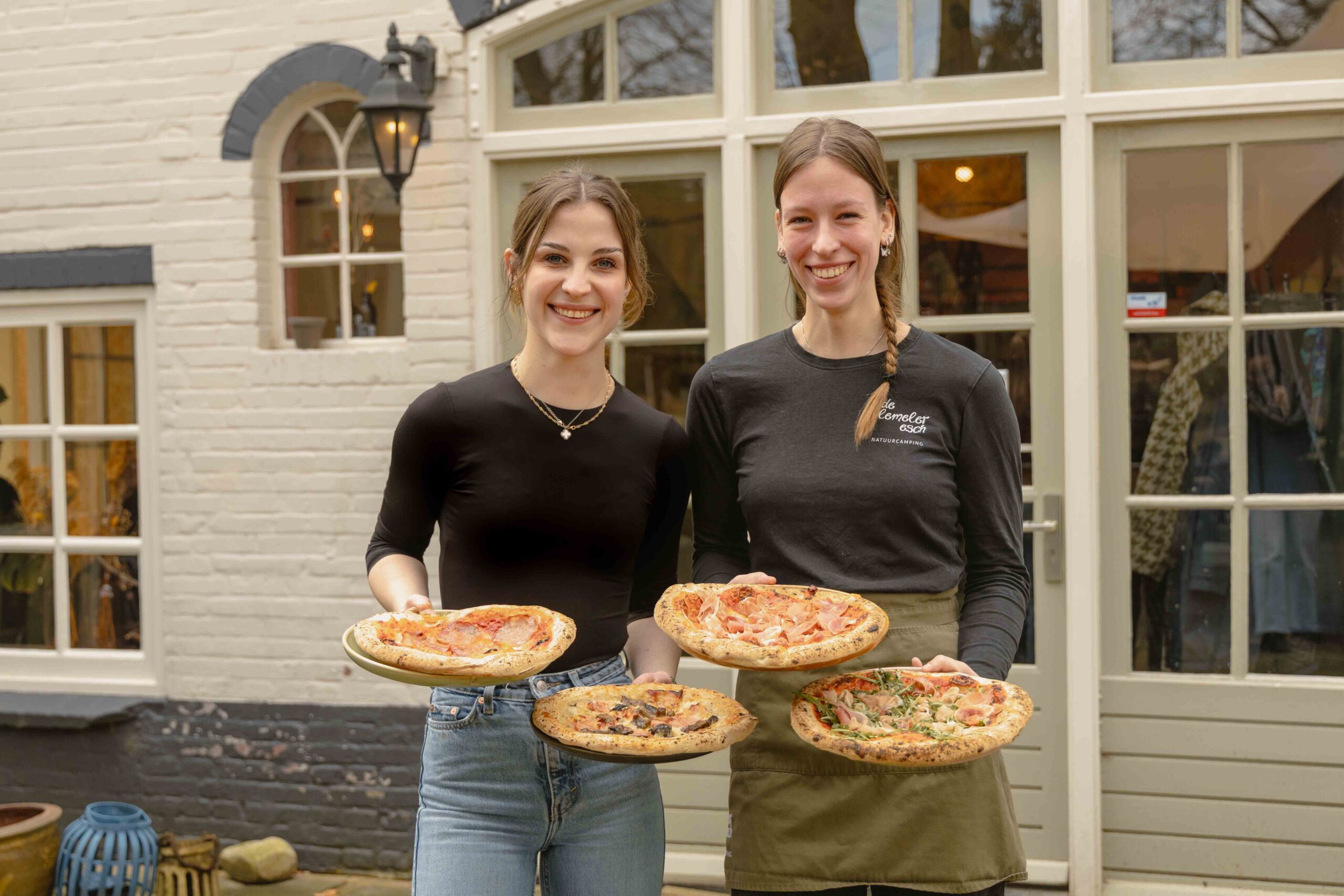 Collega's Floor en Anne met pizza's op het terras van Boscafé Lemeler Esch