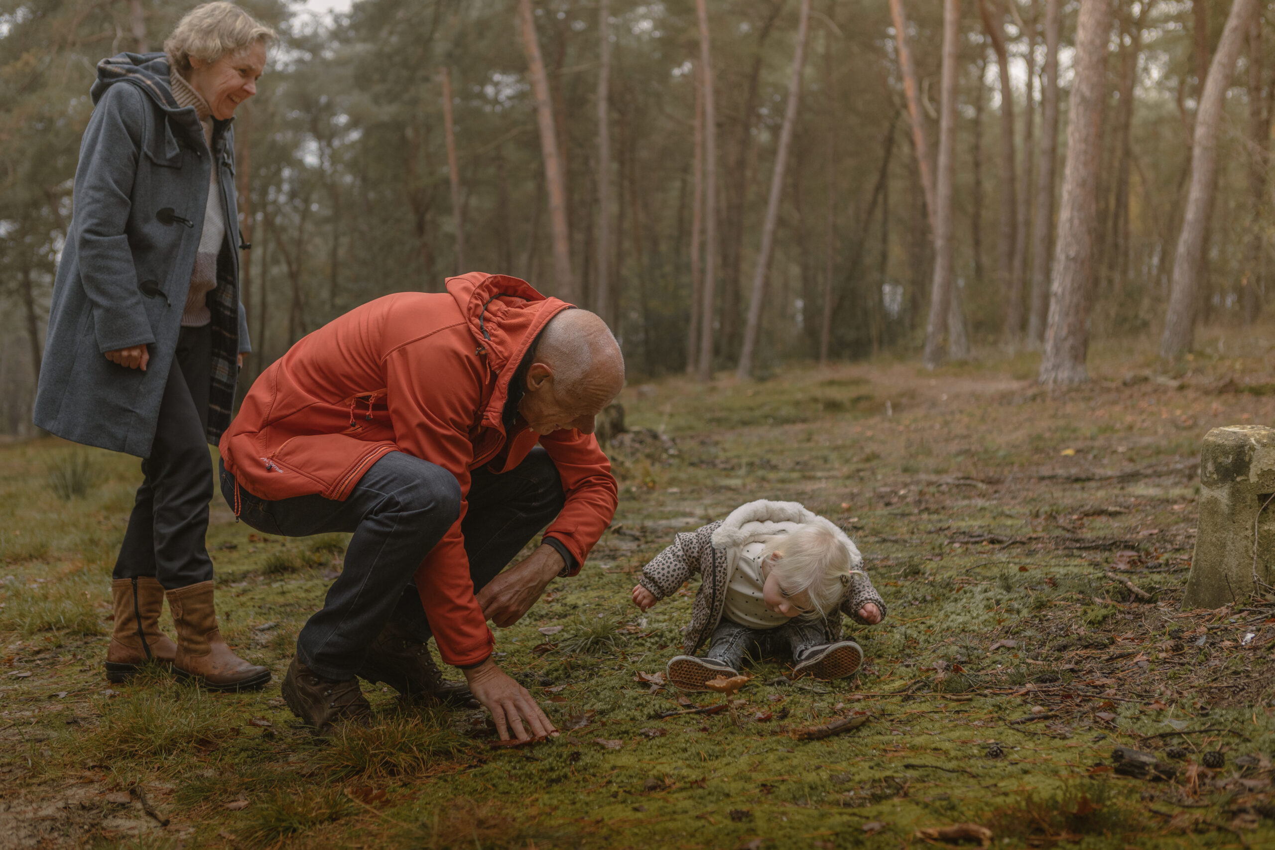Opa, oma en kleinkind ontdekken paddenstoel in het bos bij natuurcamping Lemeler Esch in Overijssel